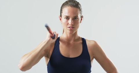 Caucasian Female Athlete Holding Javelin in Studio Setting