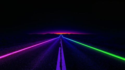 Neon highway leading to horizon with magenta and green glowing lanes at twilight