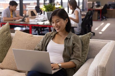Young Professional Working Relaxed on Couch in Modern Office Environment