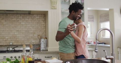 Happy Biracial Couple Dancing Joyfully in the Kitchen