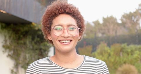 Smiling African American Woman in Stripe Top Enjoying Outdoor Garden