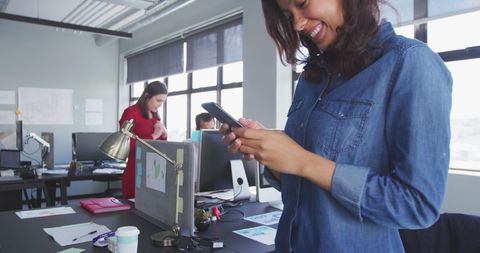 Businesswoman in Casual Denim Using Smartphone at Modern Office