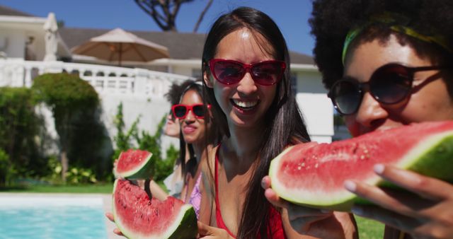 Group of friends enjoying watermelon together by the pool. They are smiling, wearing sunglasses, and basking in bright sunlight, creating a cheerful summer atmosphere. Perfect for use in advertisements, social media posts, vacation promotions, or any content related to summer fun and outdoor activities.