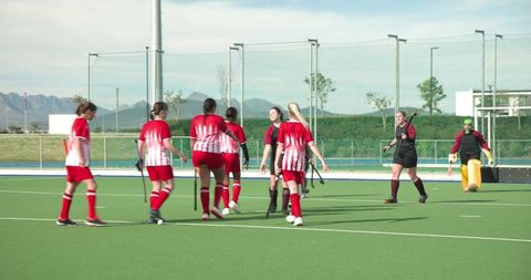 Teenage female hockey players celebrating on turf field