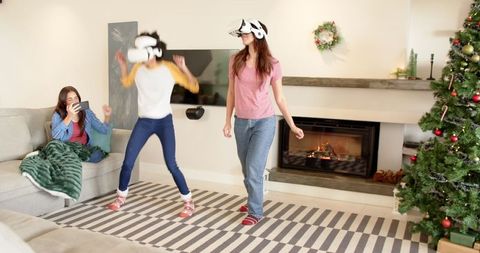 Women Enjoying VR Experience by Christmas Tree in Cozy Living Room