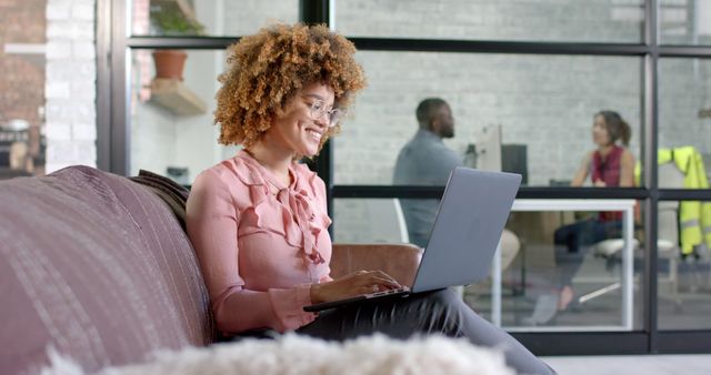 Young professional woman working on laptop in modern office lounge area - Download Free Stock Images Pikwizard.com