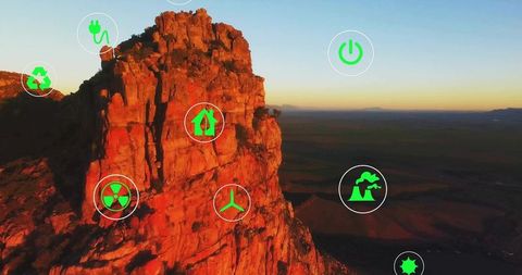Desert rock cliff and green energy icons at sunset