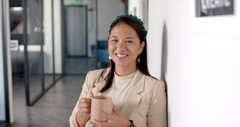 Professional woman reflecting in office hallway