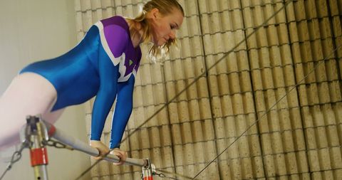 Female Gymnast Practicing on Uneven Bars Indoors - Download Free Stock Images Pikwizard.com