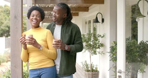 Cheerful Couple on Rustic Porch Enjoying Coffee Together
