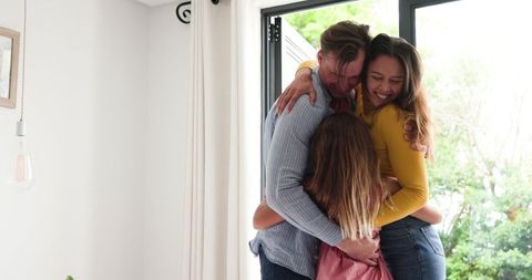 Happy Family Embracing In Bright Living Space