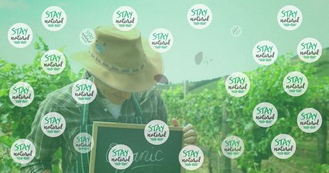 Happy Farmer Holding Chalkboard in Vineyard with Stay Natural Overlay