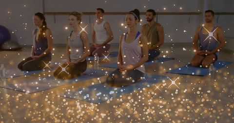 Group meditation class practicing breathwork and mindfulness with sparkling bokeh overlay