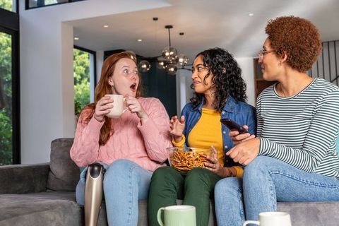Diverse Women Enjoying Cozy Chat at Home with Snacks