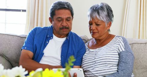 Middle-aged Couple Relaxing and Using Tablet Together