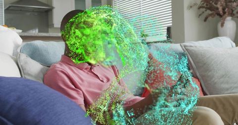 Teen using smartphone interacting with vibrant green-blue holographic ar display on sofa