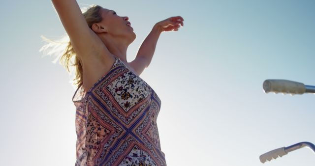 Carefree woman enjoying summer outdoors, raising arms - Download Free Stock Images Pikwizard.com