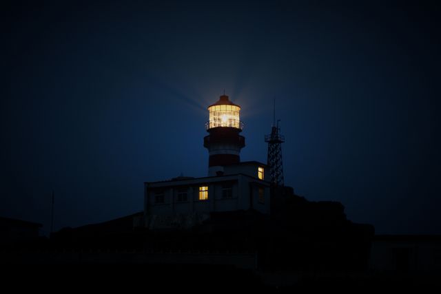 Illuminated Lighthouse with Glowing Beacon at Night - Download Free Stock Photos Pikwizard.com