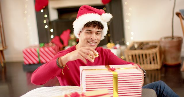 Young Man in Santa Hat Wrapping Christmas Gifts at Home - Download Free Stock Images Pikwizard.com