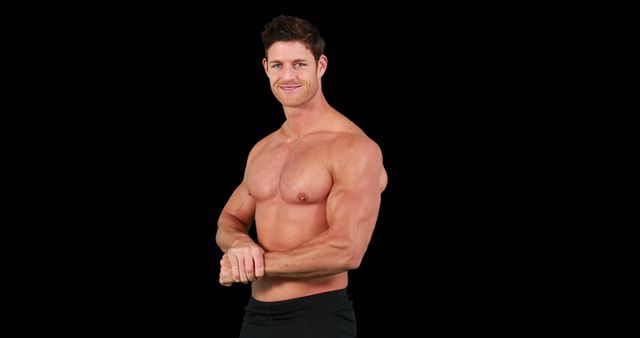 Fit man confidently smiling with arms crossed on black background. Ideal for fitness, health, bodybuilding, and lifestyle promotions. Perfect for magazine covers, workout programs, gym advertisements, and personal training websites.