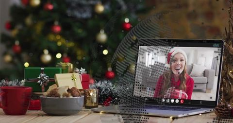 Virtual Christmas Surprise: Woman Wearing Santa Hat Waving on Holiday Video Call