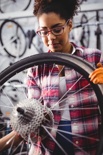 Mechanic examining a bicycle wheel in workshop