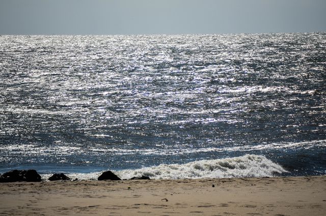 Shimmering Ocean Waves Near Sandy Beach - Download Free Stock Photos Pikwizard.com