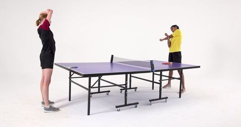 Female table tennis players stretching in studio