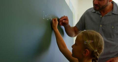 Teacher Assists Schoolgirl Solving Math Equation on Chalkboard - Download Free Stock Images Pikwizard.com