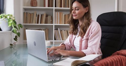 Focused Woman Working on Laptop at Home Office Desk