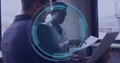 Business professionals reviewing documents with laptop hud in urban office collaboration