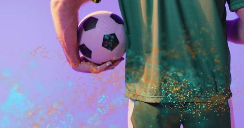 Soccer Player Holding Ball with Vibrant Confetti Effects