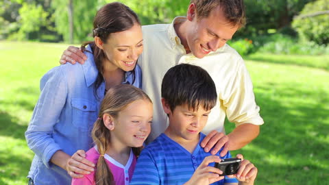 Happy Family with Children Using Camera in Countryside Setting