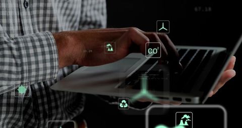 Man typing laptop with green ar sustainability icons and holographic data visualization