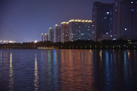 Cityscape Reflections Over Evening Lake