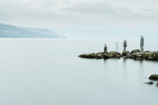Blurred Figures on Rocky Shore Overlooking Foggy Lake - Download Free Stock Photos Pikwizard.com
