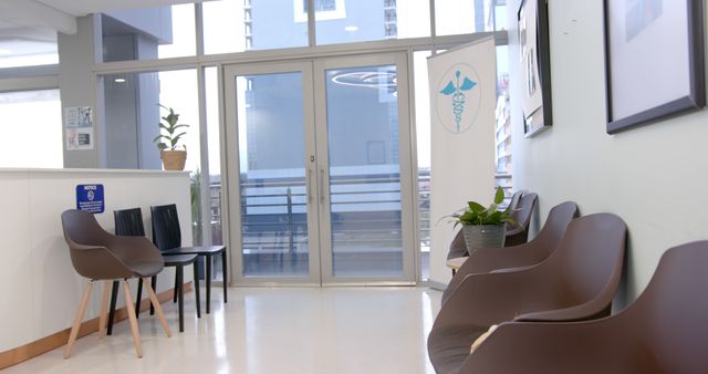 Modern healthcare facility waiting area with clean furniture and ample natural light. Glass doors provide a contemporary feel to the space. Use for medical facility promotions, healthcare interior design, or patient comfort illustration.