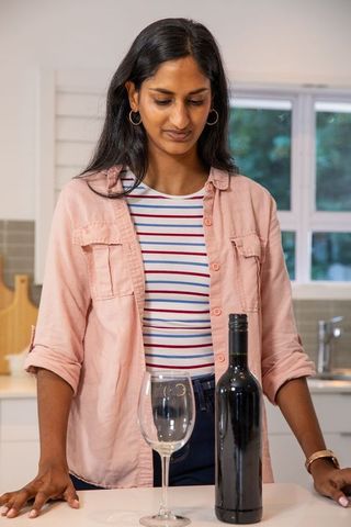 Woman Preparing to Pour Wine in Modern Kitchen Setting