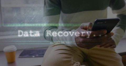 Man holding smartphone in modern workspace with data recovery overlay