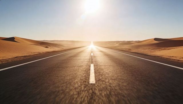 Sunlit desert highway stretching to horizon with dune landscape and vanishing point