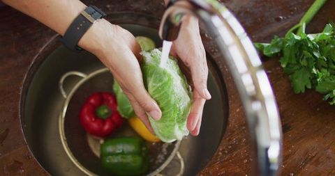 Pregnant woman washing fresh vegetables for healthy lifestyle