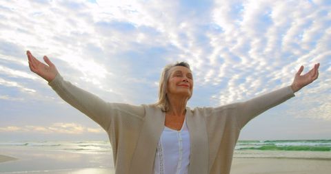 Elderly Woman Embracing Nature on Serene Beach
