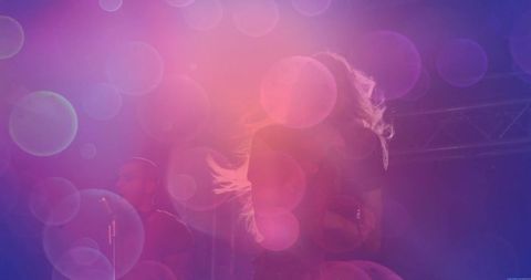 Female musician performing energetic stage show under vibrant lights