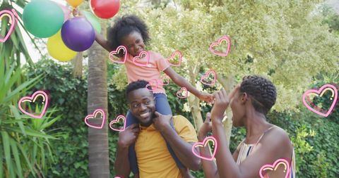 Happy African American Family Playing in Garden with Balloons