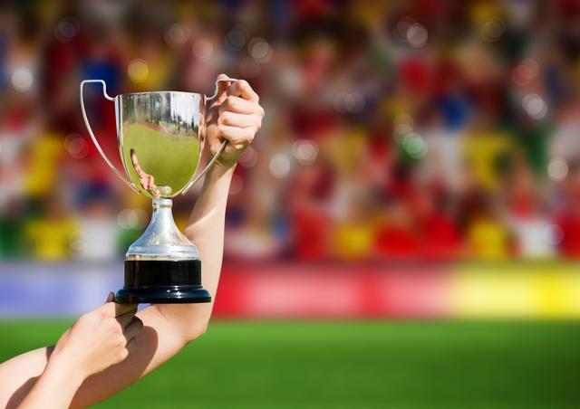 Athlete holding trophy in stadium, celebrating victory and achievement. Ideal for sports event promotions, motivational posters, and articles on success and sportsmanship.