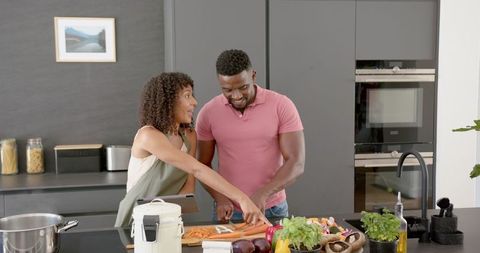 Joyful Couple Co-Cooking in Modern Kitchen Setting