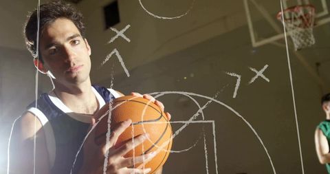 Focused athlete holding basketball surrounded by tactical markings