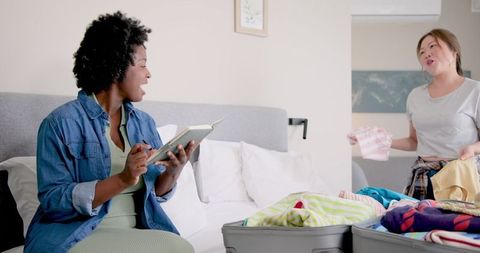 Lesbian Couple Packing for Vacation Planning Together at Home