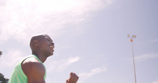 African American man enjoying a run under a clear, sunny sky. Perfect for advertisements, health campaigns, or fitness blogs emphasizing outdoor activities and physical wellness.