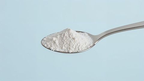 Stainless steel spoon with fine white milk powder minimalist concept